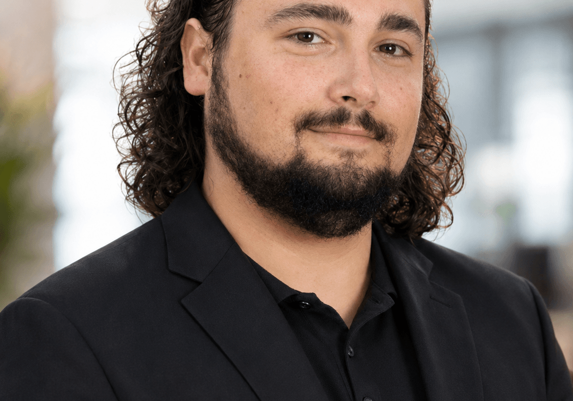 Professional man with curly hair and beard in black suit